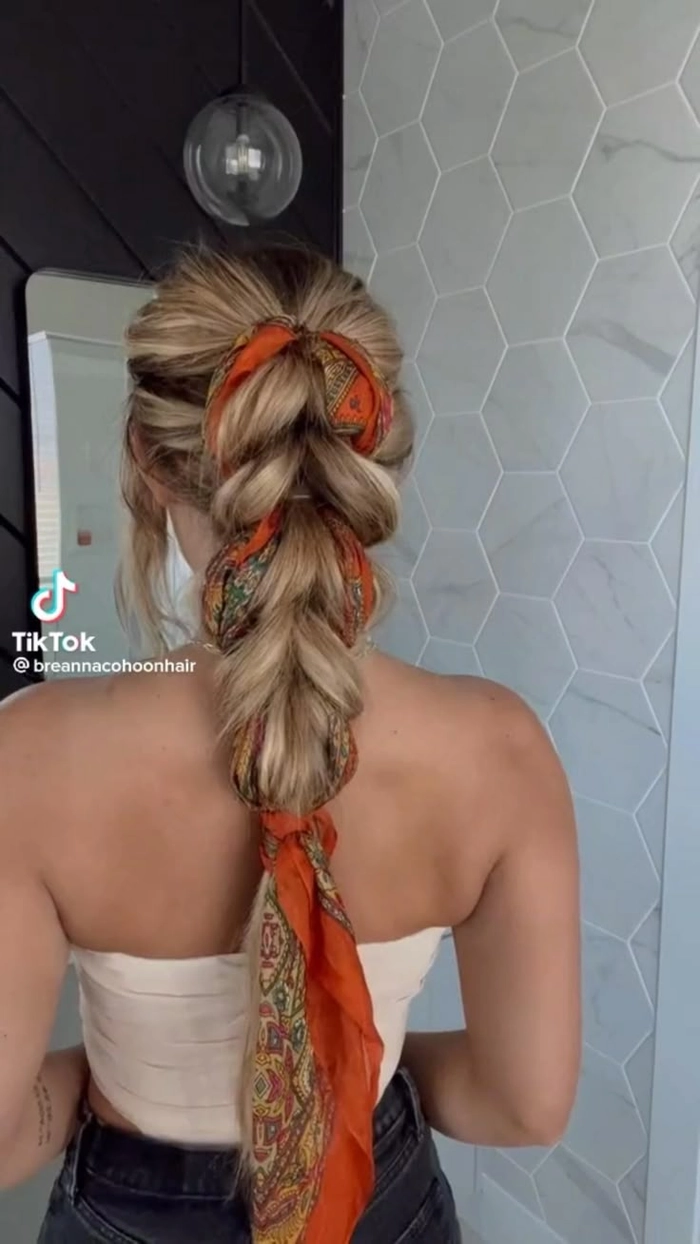 Woman with a vibrant scarf tied into a braided festival hairstyle
