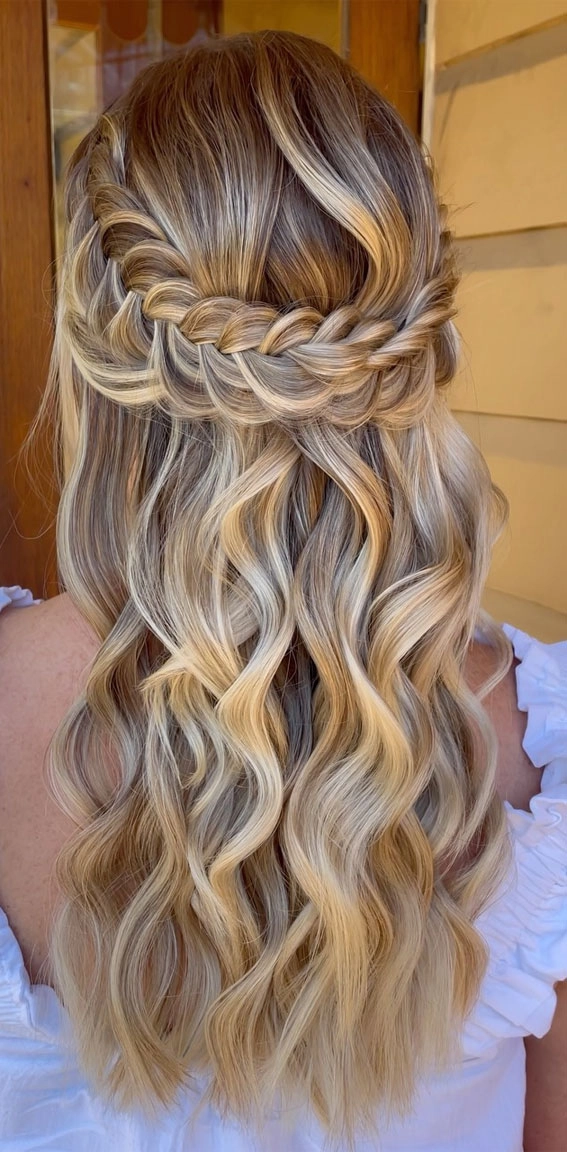 Festival half up half down hairstyle with braided crown and floral accents for outdoor concerts