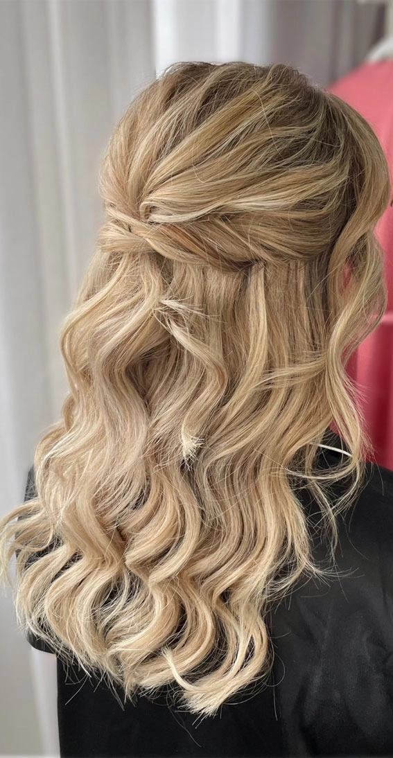 Festival half up half down hairstyle with braided crown and floral accents