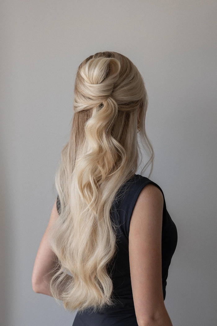 Woman with festival half up half down hairstyle featuring braided accent and tousled waves