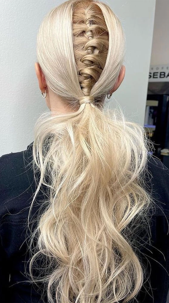 Style a high ponytail with braided wrap and floral accents for festival season