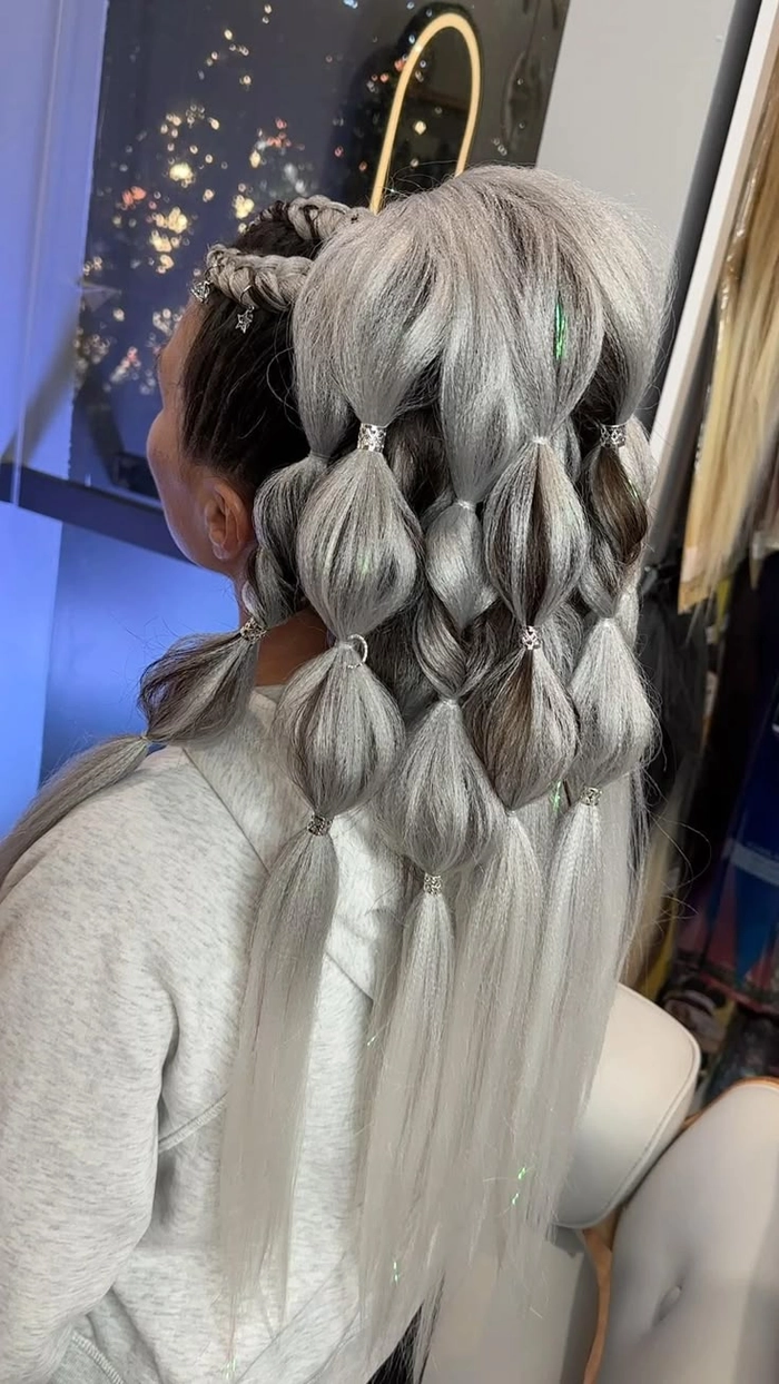 Festival ponytail hairstyle with braided accents and floral accessories