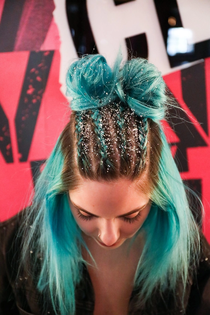 Energetic festival-goer with teased space buns and neon braids under fairy lights.