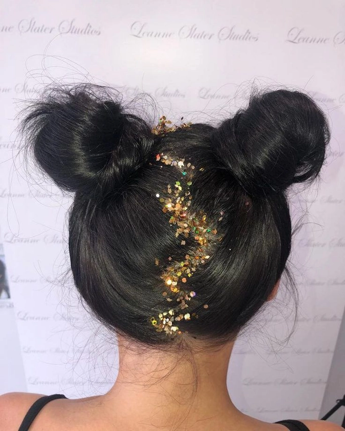 Woman with festival space buns and glitter accents