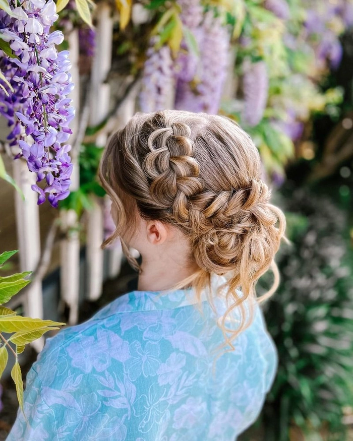 Elegant festival updo hairstyle with braided crown and floral accents