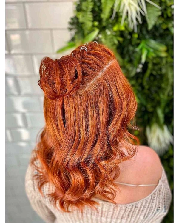 An elegant festival updo hairstyle with braided details and floral accents