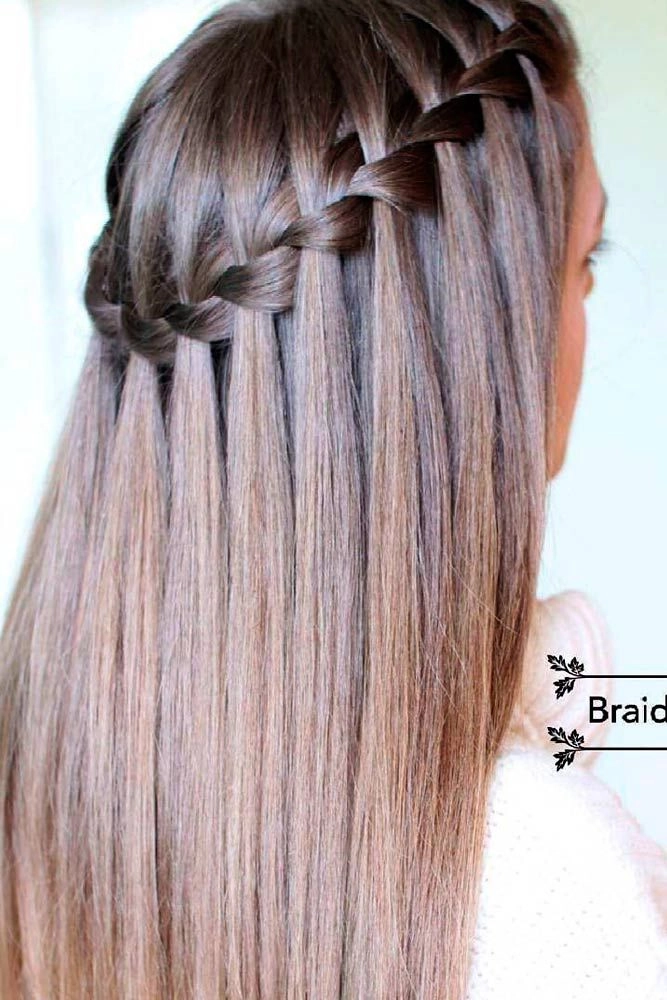 Boho waterfall braid with hair accessories perfect for outdoor festivals Side-swept waterfall braid hairstyle adorned with small flowers for a music festival