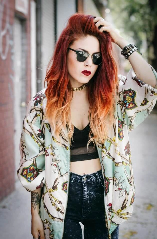 A woman with a dark, messy grunge braid and smudged makeup at an outdoor festival