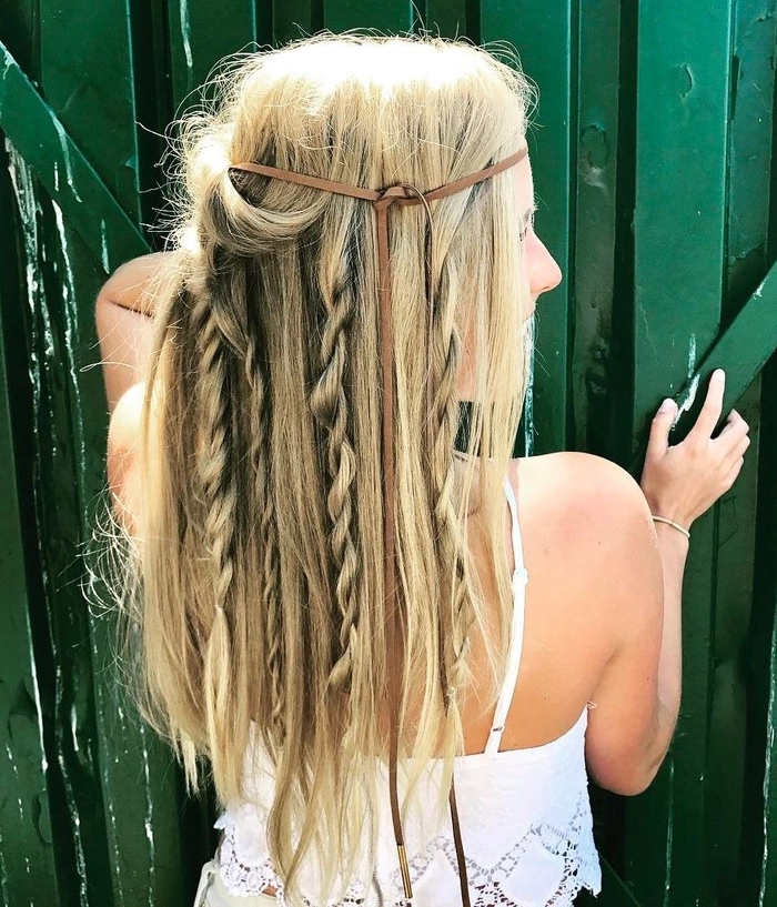 Woman with a sleek high ponytail and braided crown at a sunny outdoor festival