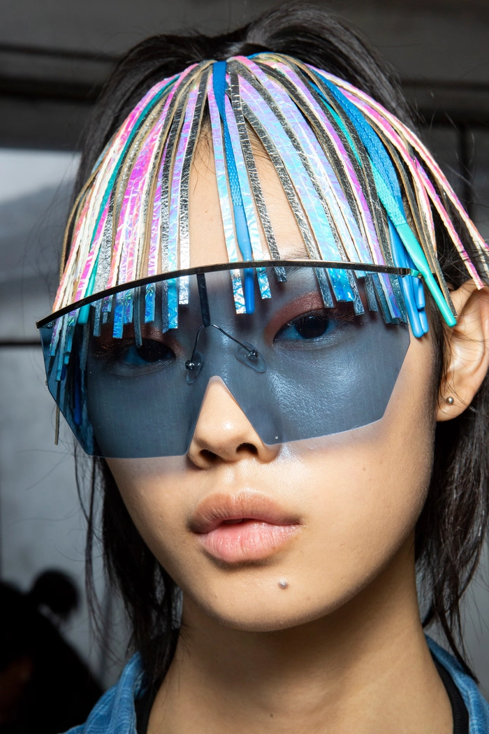 A maximalist festival hairstyle with bold braids and vibrant hair accessories.