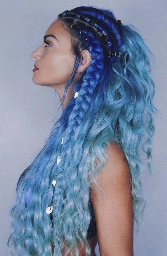 A bold maximalist festival hairstyle with intricate braids, neon ribbons, and layered accessories