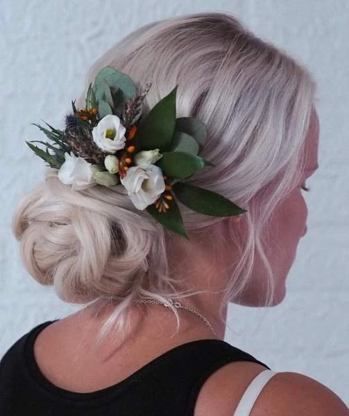 Festival hairstyle featuring messy braids and wild floral accents Messy braided festival hairstyle with colorful hair accessories