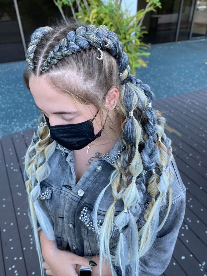 Braided updo with mud-streaked highlights at a festival