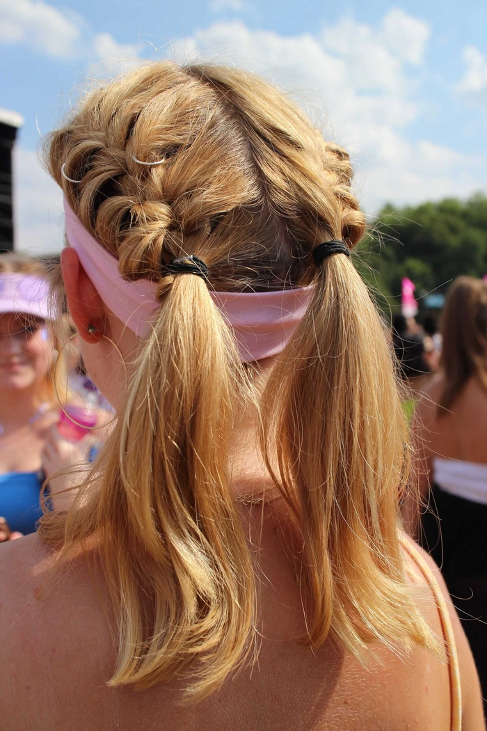 Muddy festival goer with braided hair and mud-splattered face