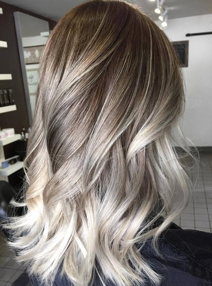 Balayage Ideas for Graduation Hair - Long Wavy Style with Subtle Sun-Kissed Color Stylish graduation hairstyle with soft balayage highlights blending from dark roots to light ends.