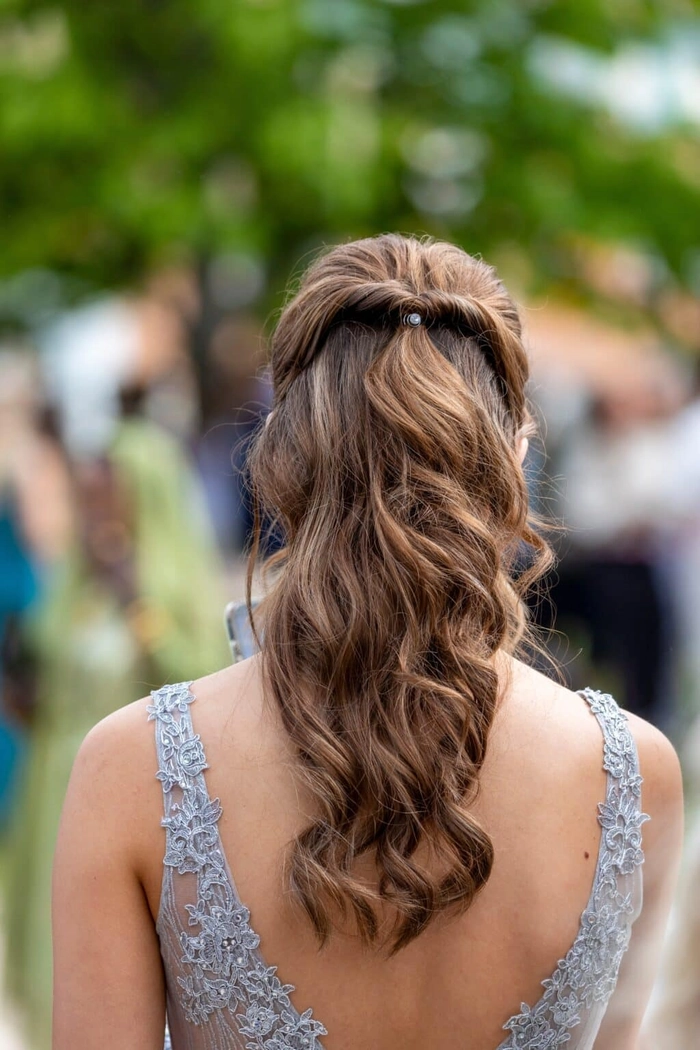 Elegant boho graduation hair inspiration with braids and flowers Boho chic graduation hairstyle with loose waves and floral accessories