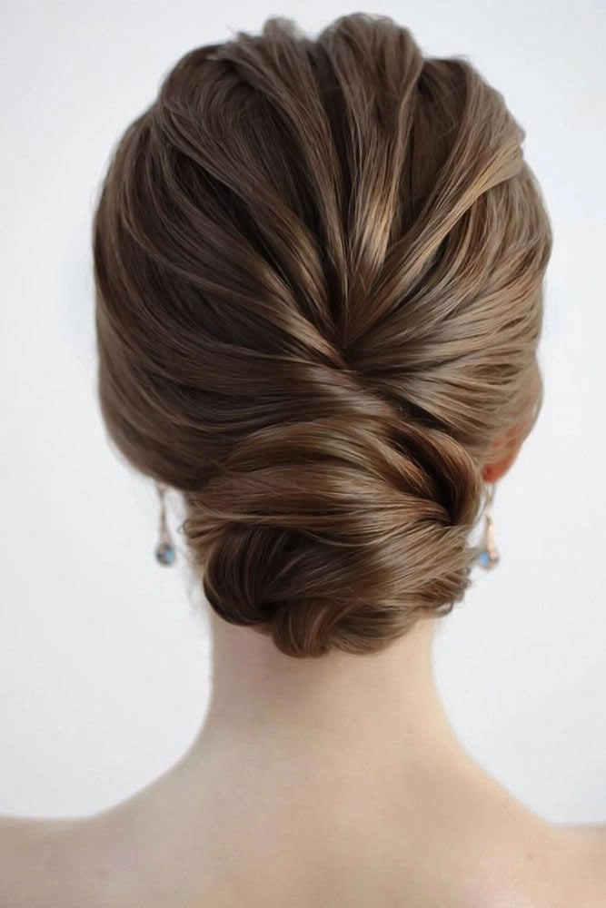 Chignon bun graduation style with elegant twisted details and subtle accessories