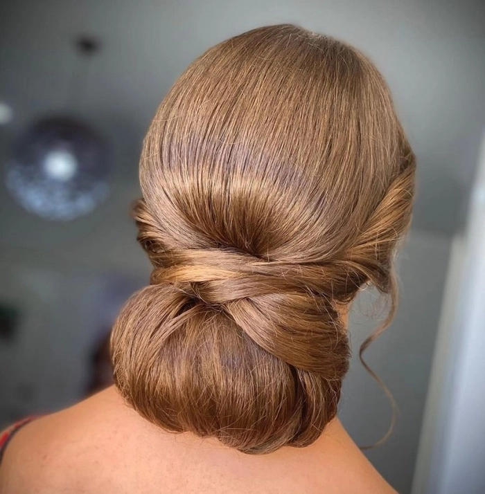 Elegant chignon bun graduation hairstyle with sleek finish and decorative accents