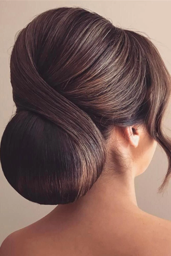 Elegant chignon bun graduation hairstyle with soft curls and a pearl pin