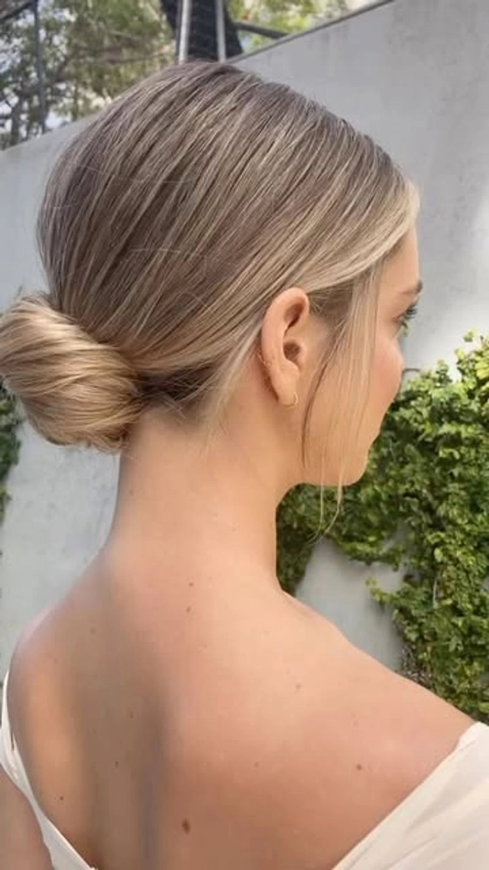 Elegant graduation chignon bun with polished finish and subtle side part