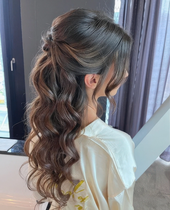Elegant classic graduation updo with soft curls and pearl accents