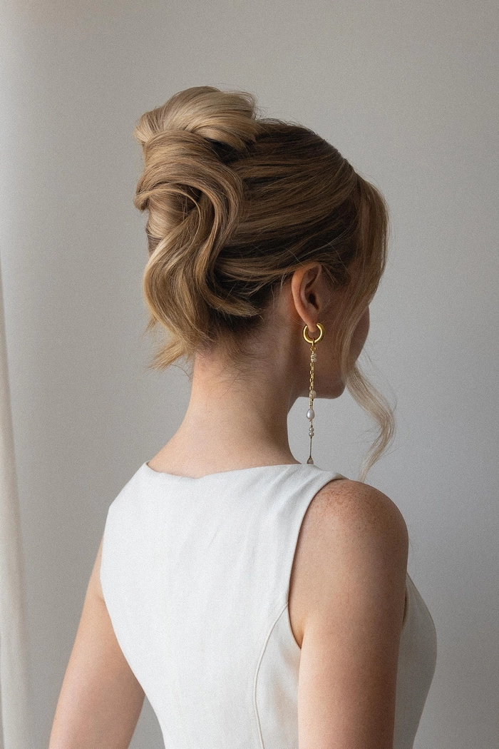 Elegant French twist graduation updo with soft curls and volume