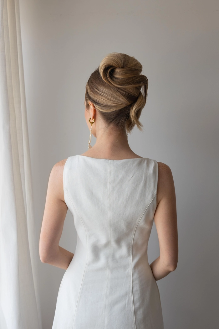 Elegant French twist updo hairstyle for graduation with smooth twisted back and subtle volume at the crown