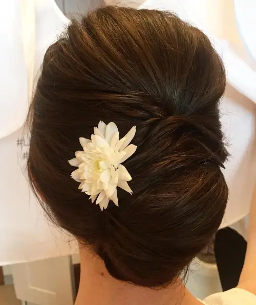 Elegant French twist graduation updo with soft waves and decorative pins