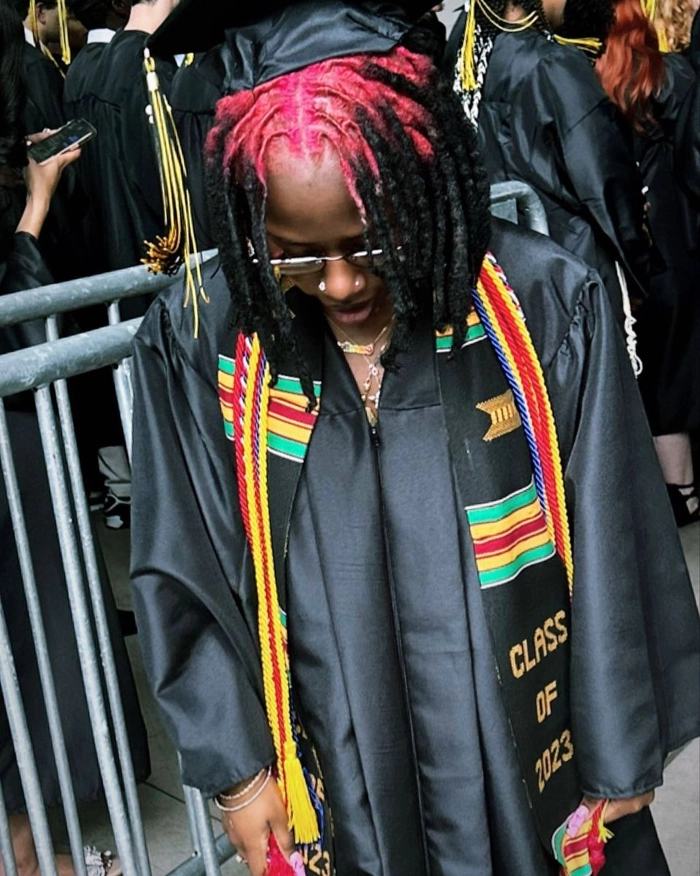 Elegant locs hairstyle styled perfectly for a graduation cap Graduating student with beautiful locs peeking from under graduation cap