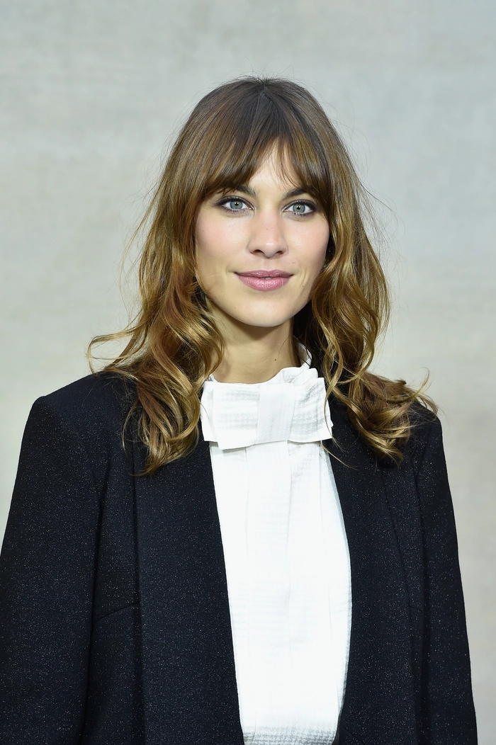 Graduation hairstyle featuring soft waves and bangs pinned to the side