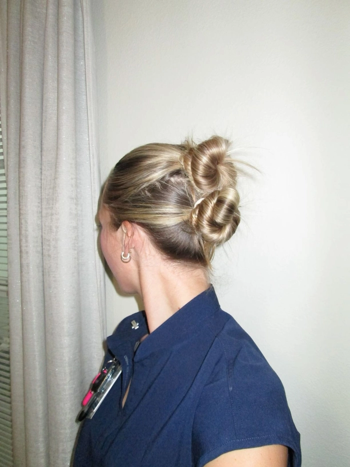 Nursing student with a sleek low bun graduation hairstyle and stethoscope
