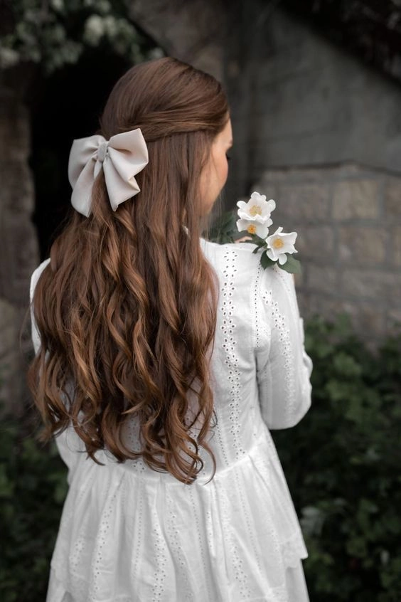 Chic ribbon-accented graduation updo perfect for the ceremony Elegant graduation hairstyle with satin ribbons and soft curls