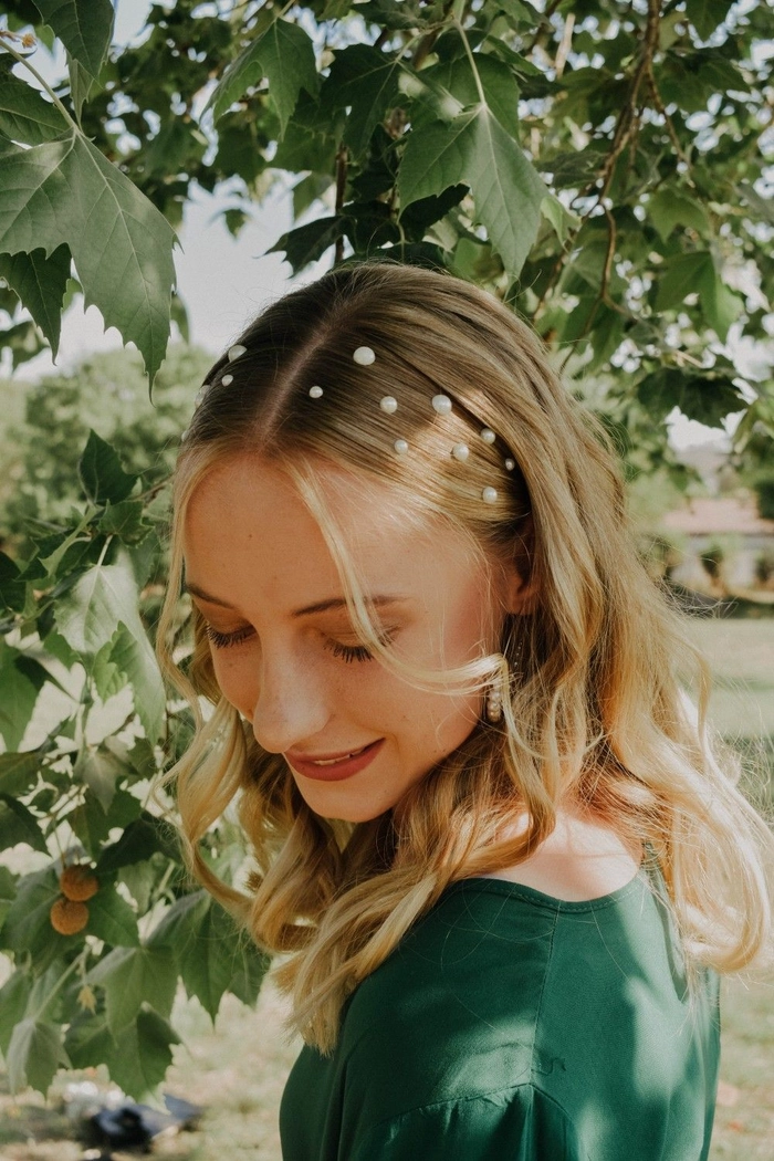 Pearl hairpin accent for a sophisticated graduation updo Elegant graduation hairstyles adorned with delicate pearl hairpins