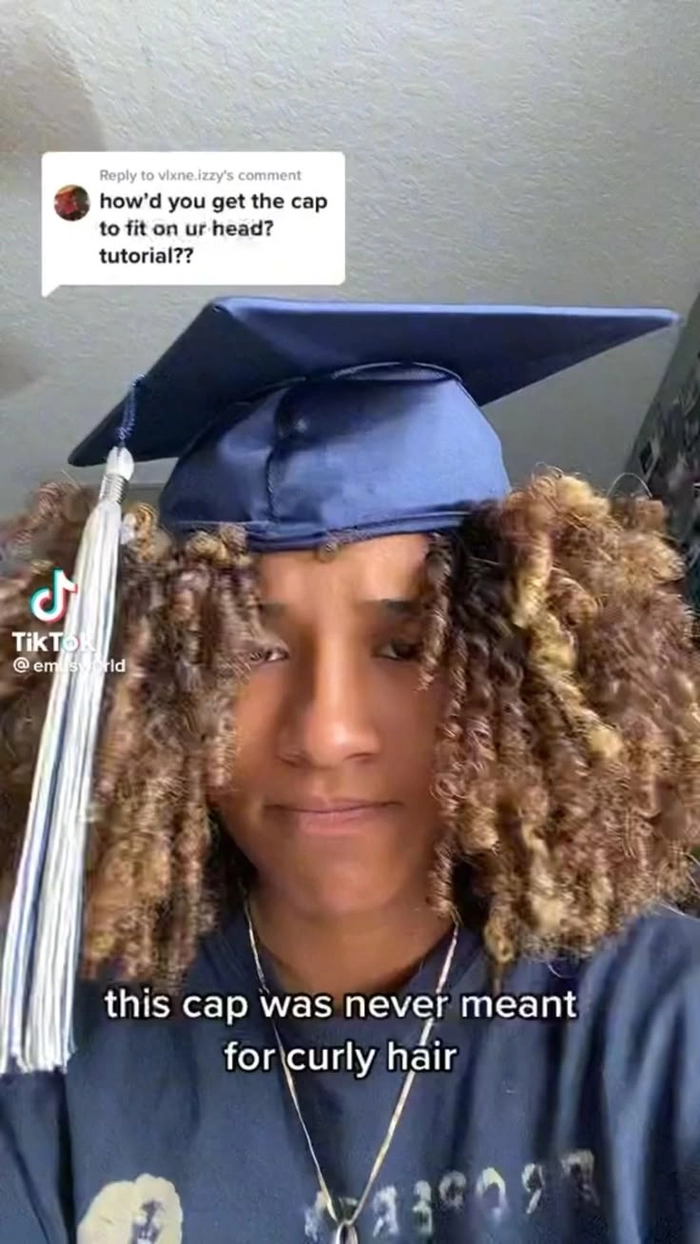 Graduating student with long hair flowing beneath her cap at commencement ceremony