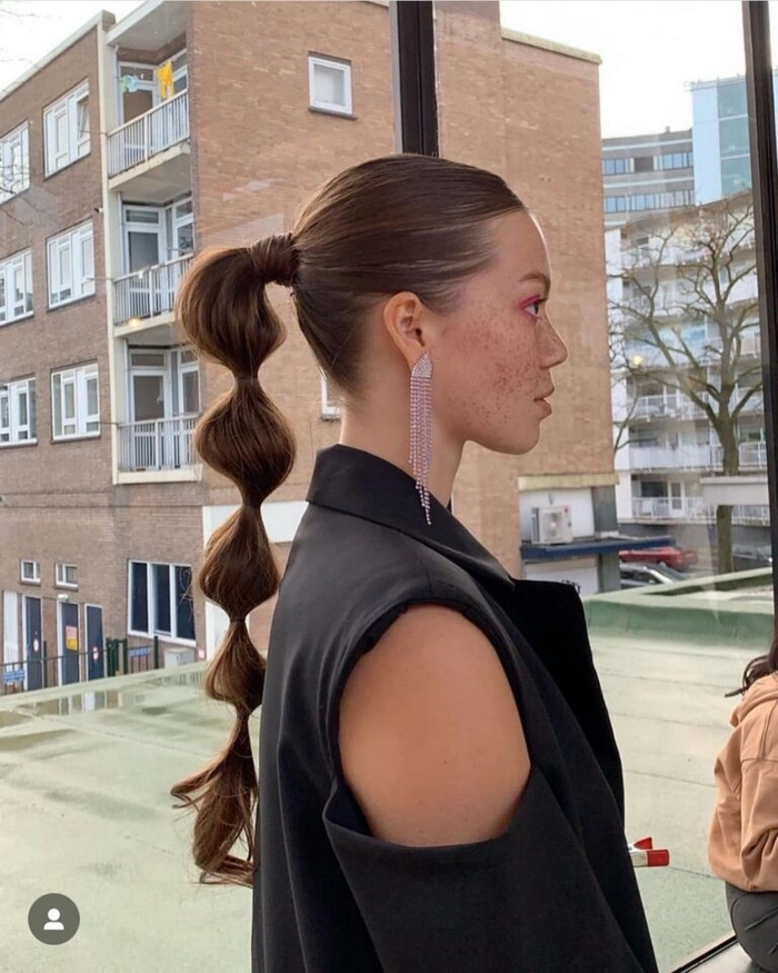 Elegant high ponytail graduation hairstyle with sleek sides and soft curls