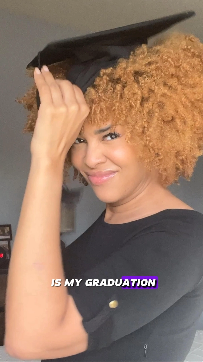 Graduate with natural hair wearing a graduation cap and gown