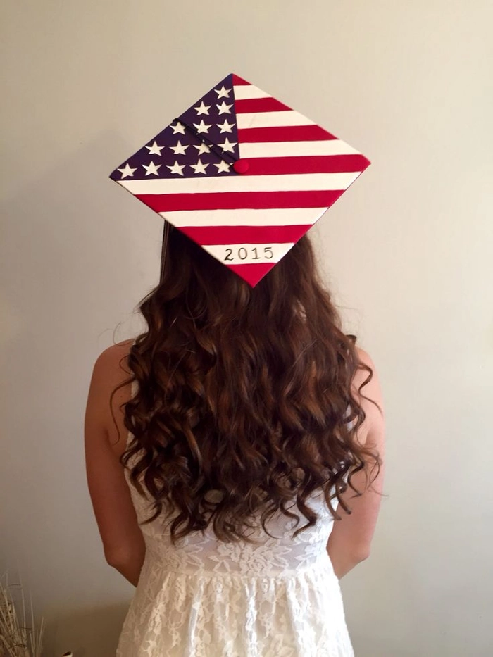 A graduate's hair pinned up beneath a graduation cap, with bobby pins hidden under the cap