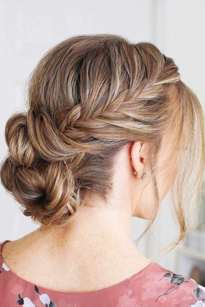 Graduation hairstyle with a stylish messy bun accented by soft tendrils and decorative pins