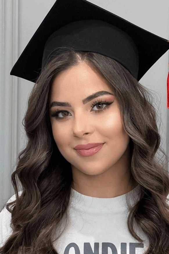 Side swept hair peeking out from under a graduation cap