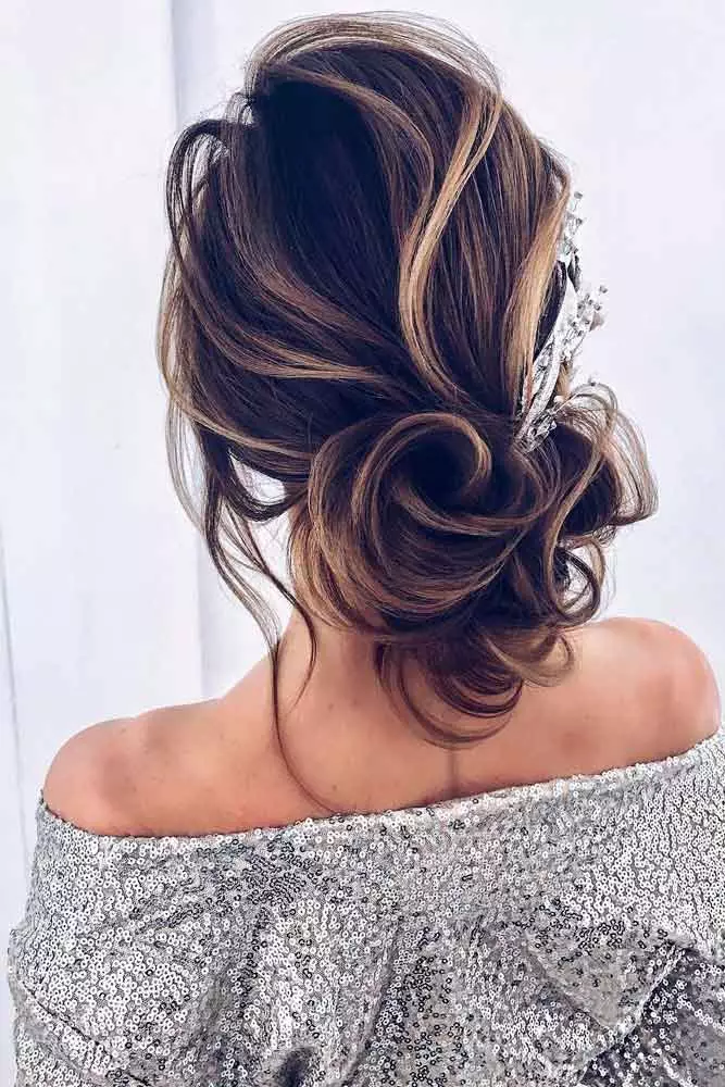 Elegant graduation updo with soft curls and pearl accents, styled high at the crown
