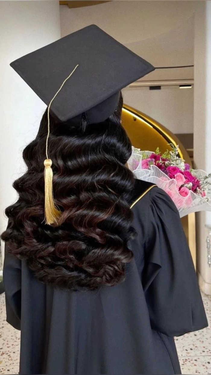 An example of a low bun hairstyle worn with a graduation cap, showing how the bun sits comfortably below the cap