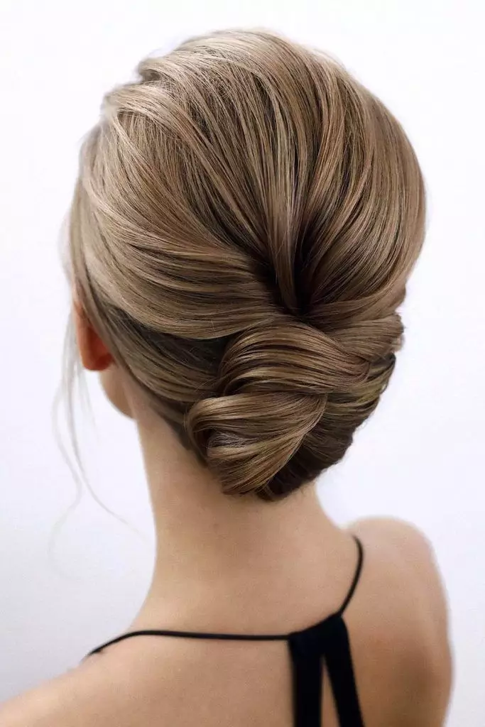 Low bun hairstyle neatly styled under a graduation cap