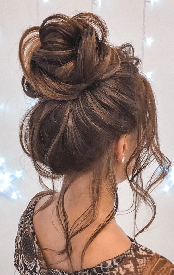 A stylish messy bun graduation look with voluminous twists and soft flyaways