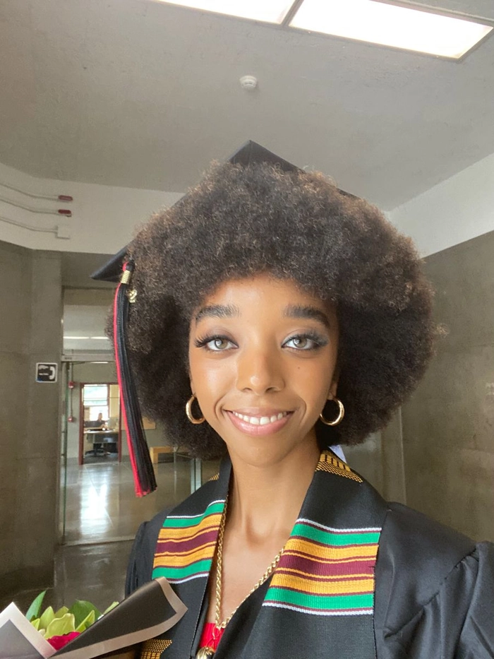 Graduate proudly wearing natural hair under a graduation cap
