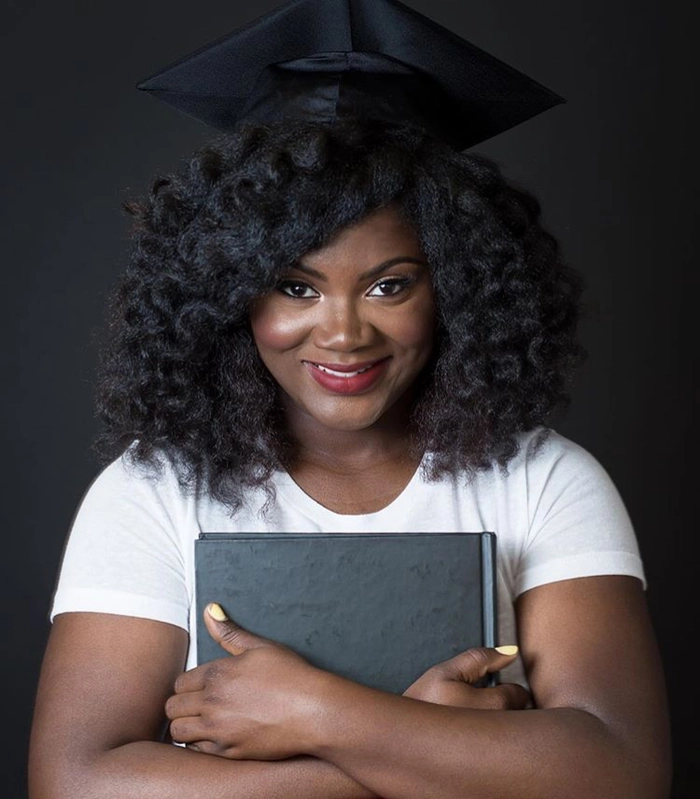 Proud graduate wearing natural hair with graduation cap