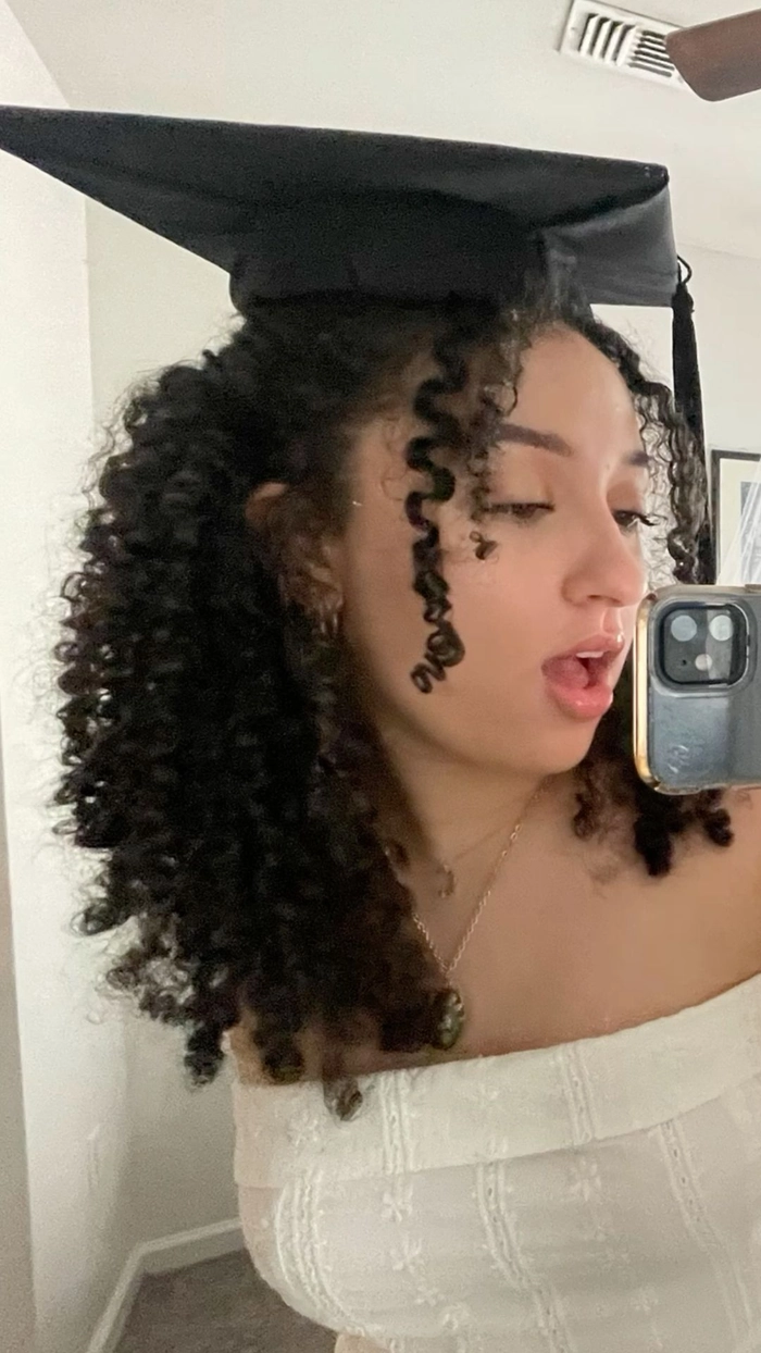 Graduate with natural hair wearing a graduation cap
