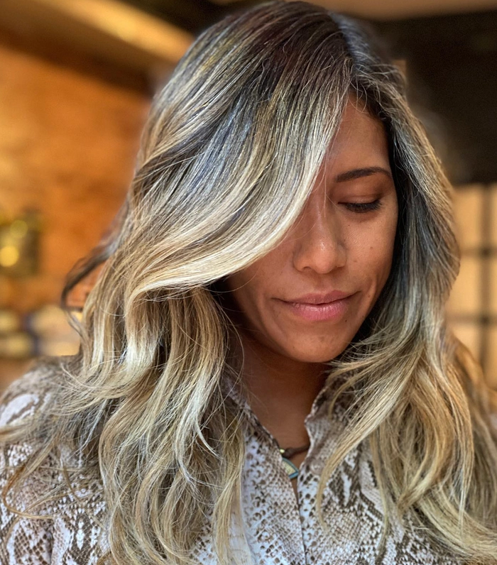 A woman styling a quick messy bun for graduation, perfect for busy mornings