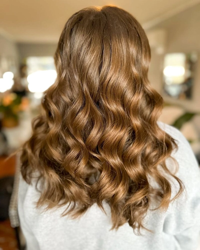 Romantic loose curls hairstyle for graduation with soft waves and a delicate lace dress