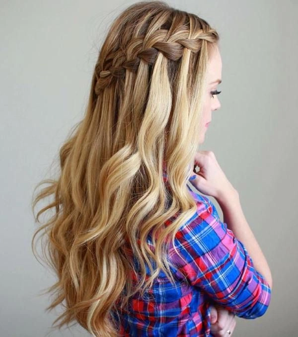 Waterfall braid graduation hairstyle with subtle accessories for cap and gown