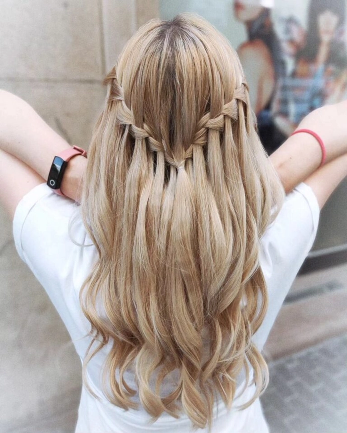Graduation hairstyle with waterfall braid and floral accents